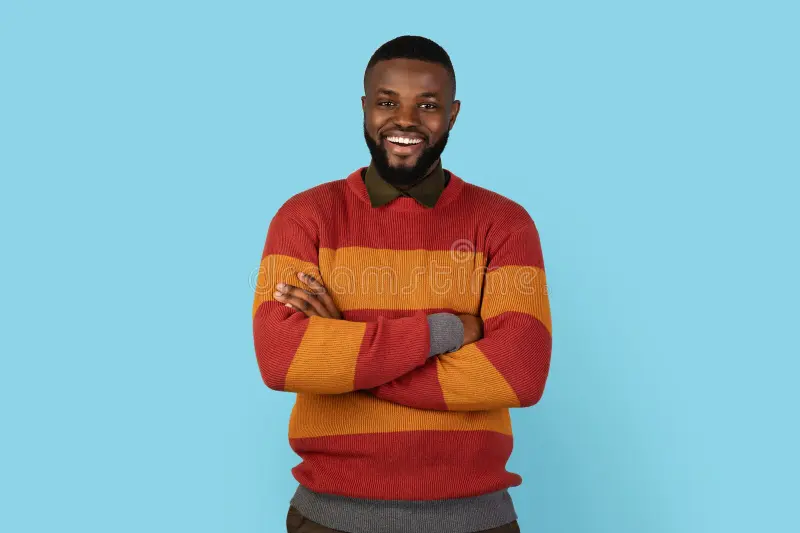 Confident young man smiling with arms crossed
